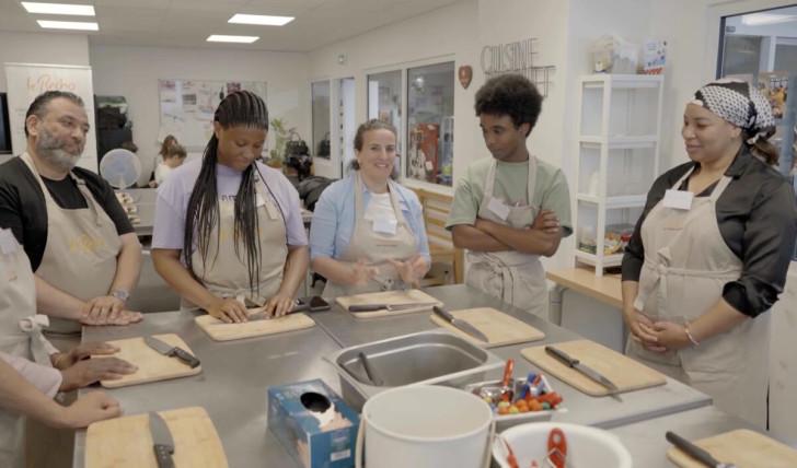 Des habitants participant à un atelier de cuisine solidaire à Paris